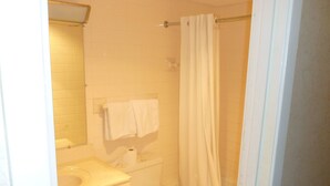 Une petite salle de bain propre, équipée de toilettes, d’un lavabo et d’une baignoire.
