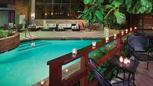 An indoor pool area with a checkered floor, seating, and candles.