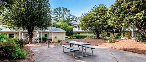 A picnic table in a courtyard with a view of a row of townhouses.