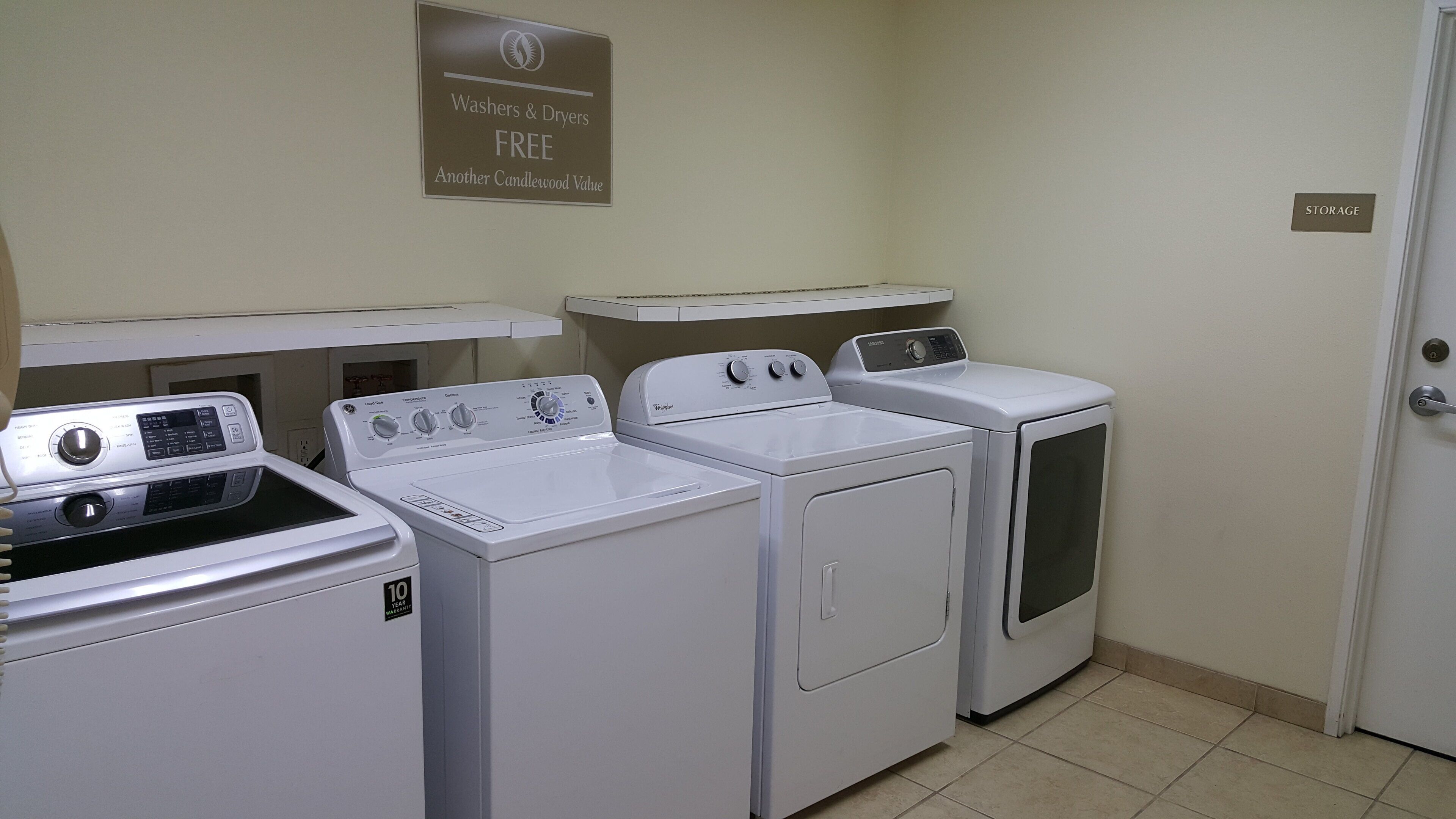 A laundry area with washers and dryers, a sign indicating free washers and dryers, and a storage sign on the wall.