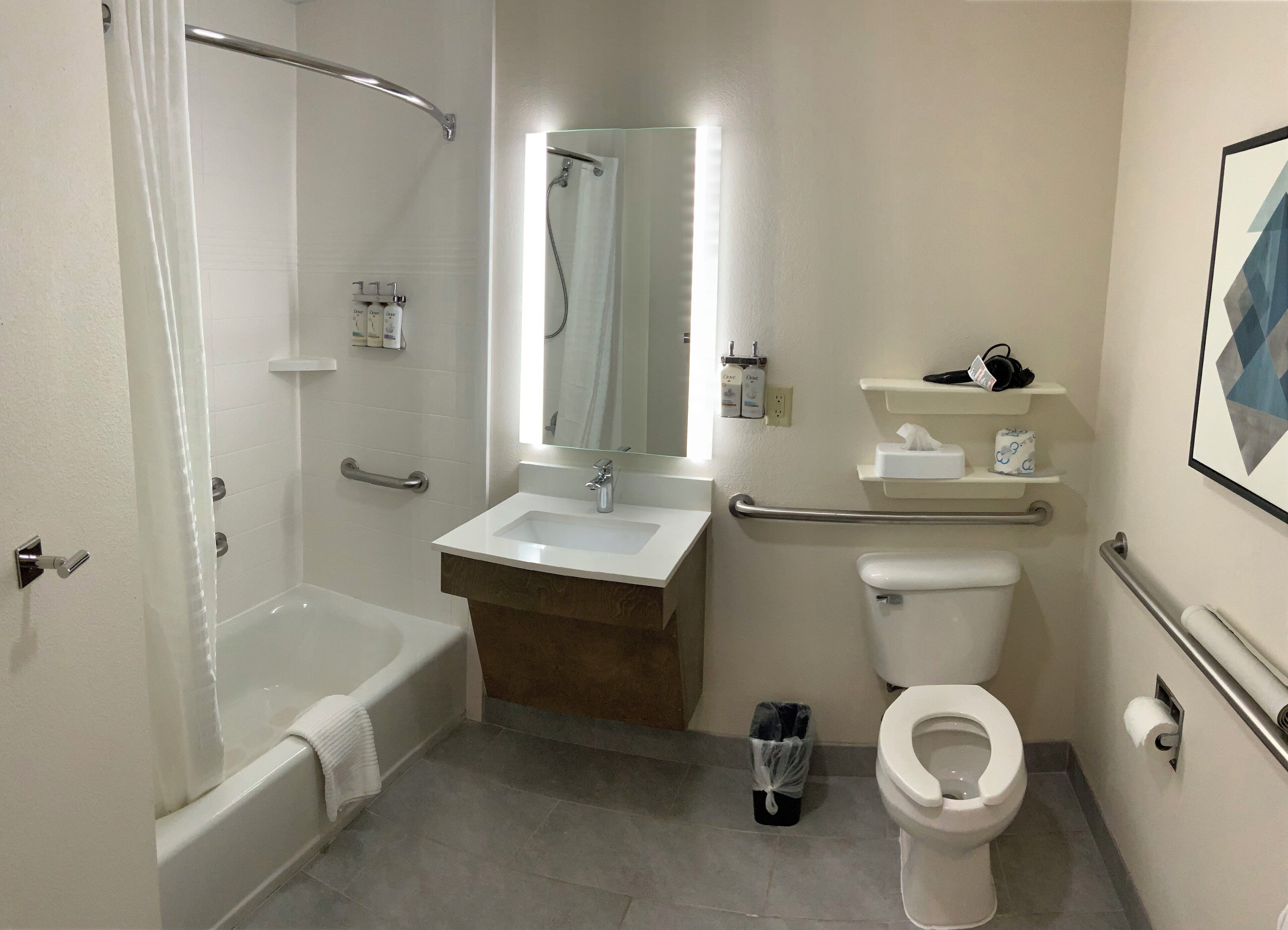 Un baño moderno con bañera, lavamanos, inodoro y zona de ducha.