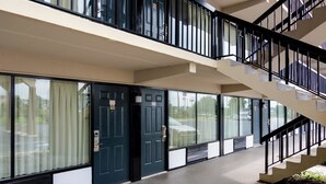 A modern building with a double staircase, large windows, and a flat facade. - Motel 6 Macon, GA (Macon)
