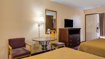 A hotel room with two beds, a desk with a chair, a TV, and a mirror.