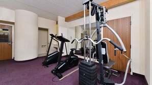 Ein Fitnessraum mit Cardiogeräten und einer Gewichtbank.