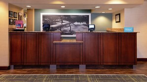 A hotel reception desk with a large 'dream.' sign, a digital kiosk, and a 'Hilton Honors' sign. - Hampton Inn Greensboro-Airport (Greensboro)