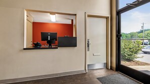 A reception area with a desk, phone, and flat-screen TV.