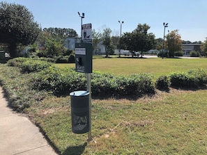 A dog waste station with a sign instructing to clean up after your dog.