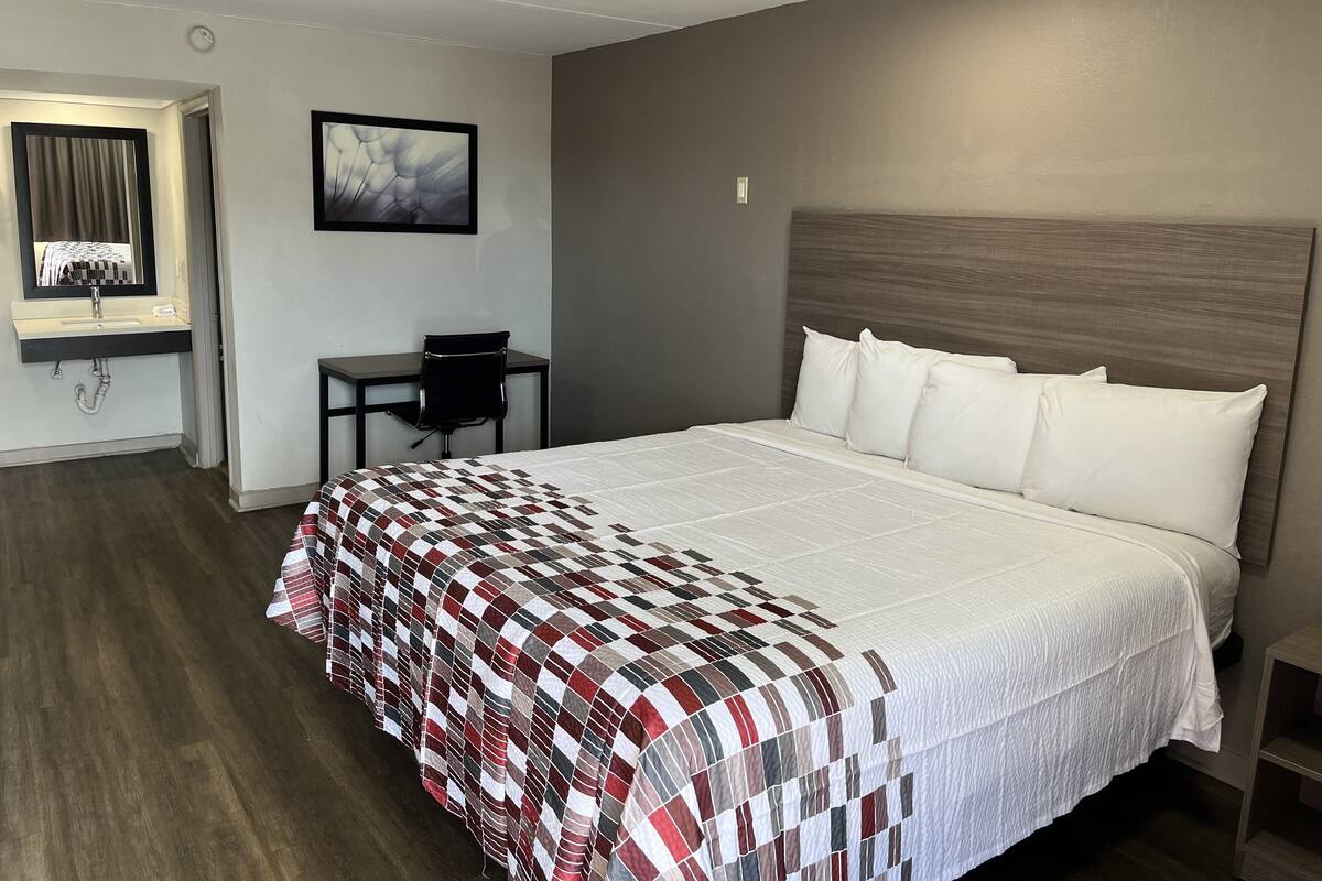 Een hotelkamer met een groot bed, een bureau en een stoel.