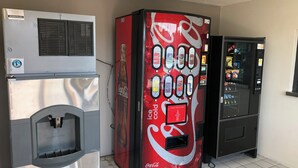 A vending machine with a Coca-Cola logo, a beverage dispenser, and a Coca-Cola refrigerator.