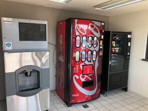 A vending machine with a Coca-Cola logo, a beverage dispenser, and a Coca-Cola refrigerator.