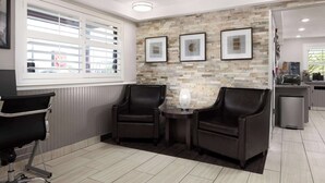 A modern room with two leather chairs, a small table, and a decorative vase.
