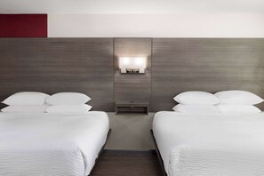 A hotel room with two beds, a nightstand, and a wall-mounted light fixture. - Ramada by Wyndham Medford Airport North (Medford)