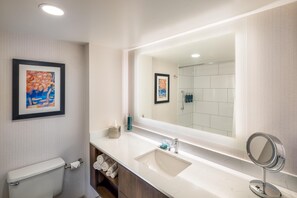 A modern bathroom with a large mirror, white tiles, a toilet, and a towel rack. - DoubleTree by Hilton Hotel Oak Ridge - Knoxville (Oak Ridge)