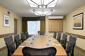 A conference room with a long table, black chairs, and water bottles. - DoubleTree by Hilton Hotel Oak Ridge - Knoxville (Oak Ridge)