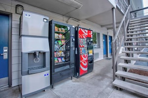 A vending machine area with a Coca-Cola machine, a water dispenser, and a snack vending machine.