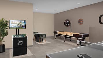 A billiards room with a pool table, a snooker table, and a television displaying a sports event.
