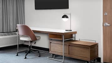 Un escritorio moderno con una silla, una lámpara de escritorio y un mueble de almacenamiento de madera.