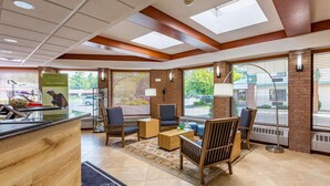 A lobby with a reception desk, seating area, and large windows with blinds. - Country Inn & Suites by Radisson, Traverse City, MI (Traverse City)