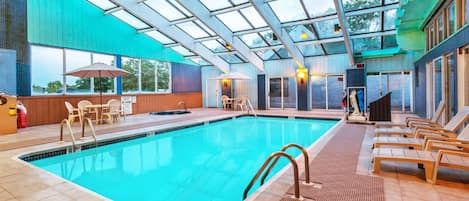 Una piscina techada, sillones reclinables de piscina