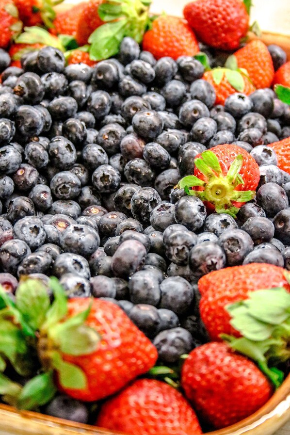 Una cesta llena de arándanos y fresas.