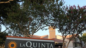 Et hotelskilt med navnet "LA QUINTA BY WYNDHAM" og et sollogo.