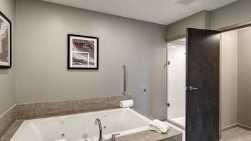 A bathroom with a bathtub, a shower, and a door.