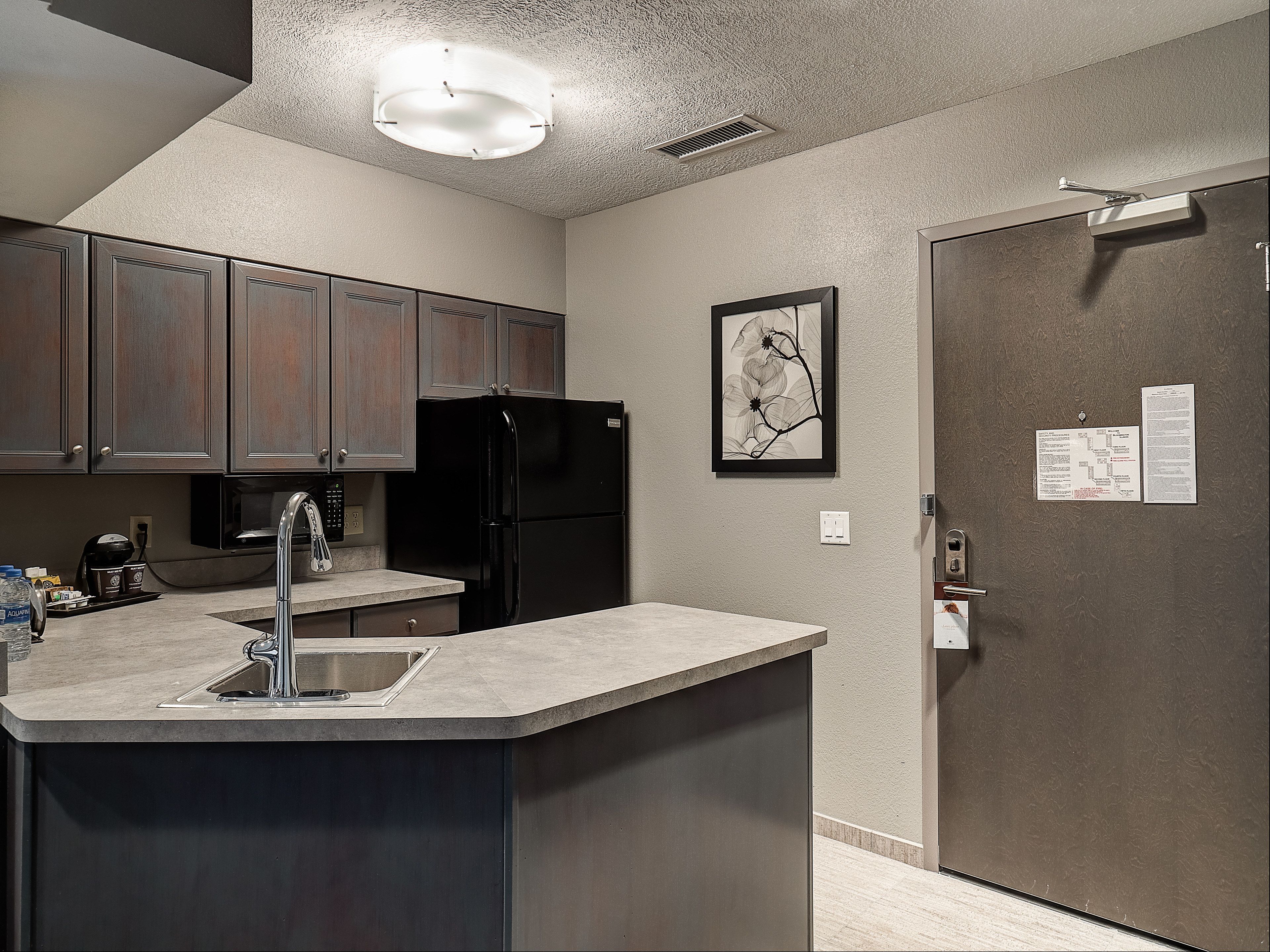 A kitchen with a built-in island, stainless steel appliances, and a microwave.