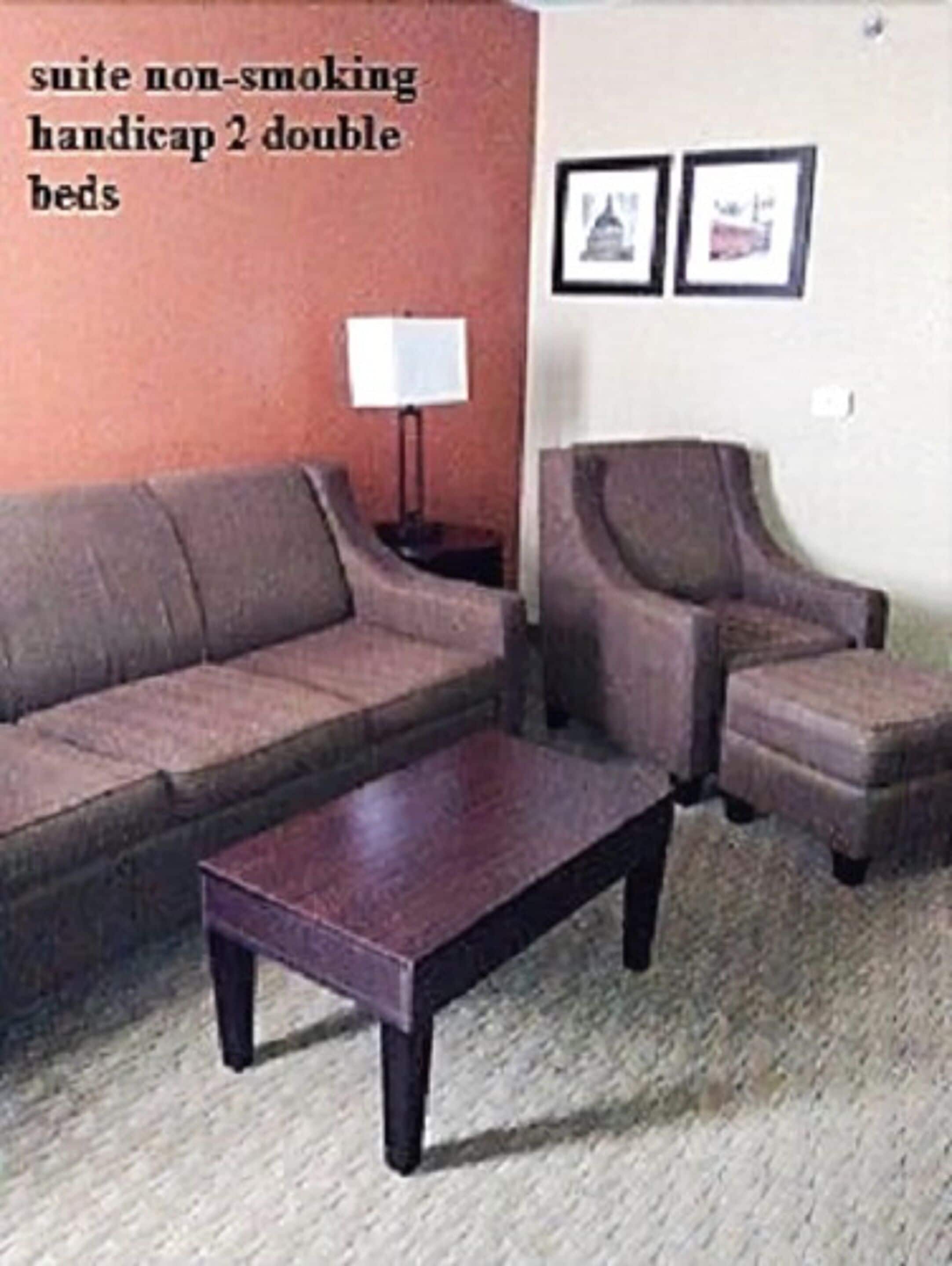 A suite with non-smoking, handicap 2 double beds, a sofa, two armchairs, and a small table.