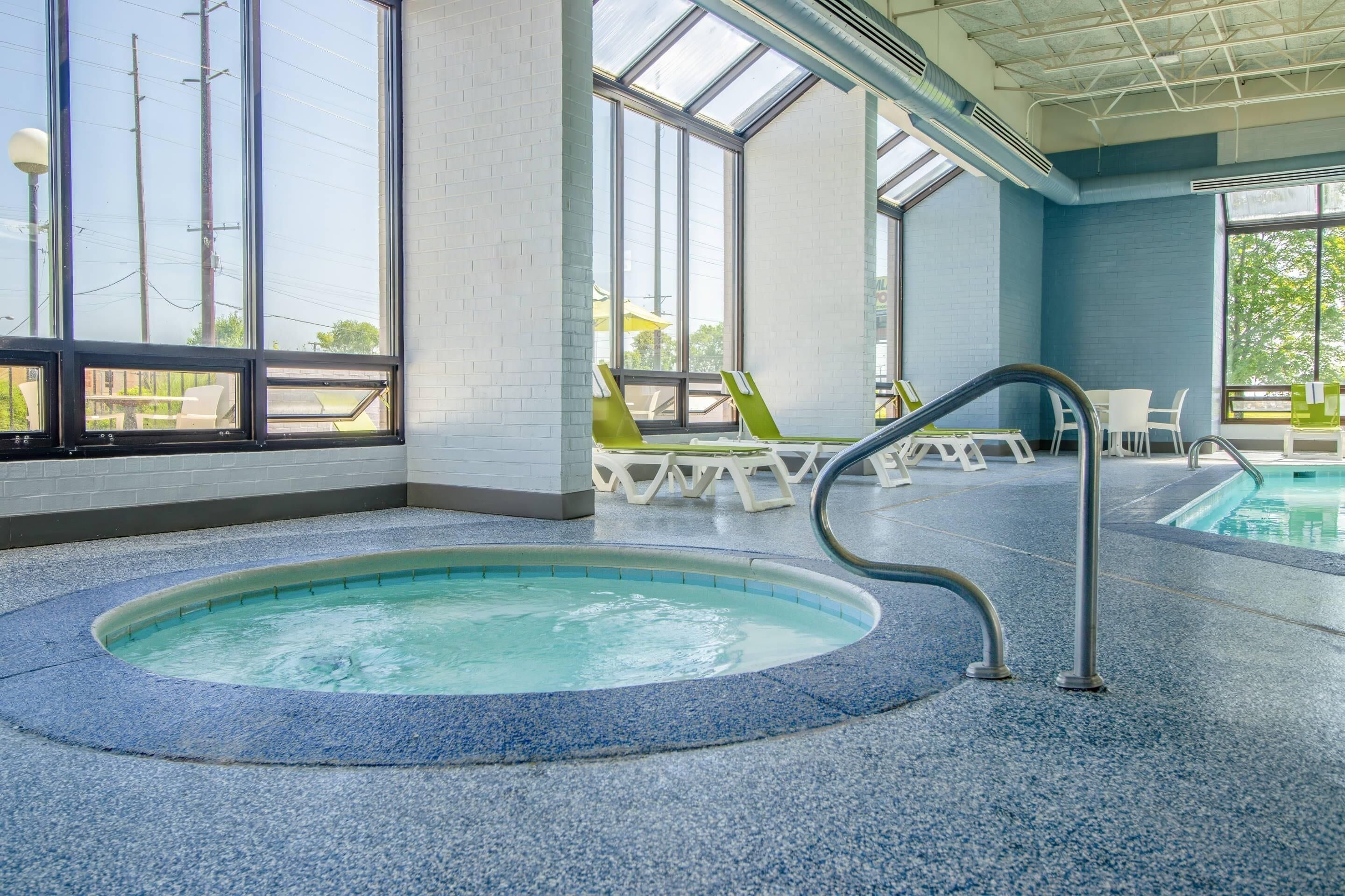 An indoor swimming pool with a clear view of the outside through large windows.