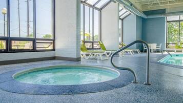 An indoor swimming pool with a clear view of the outside through large windows.