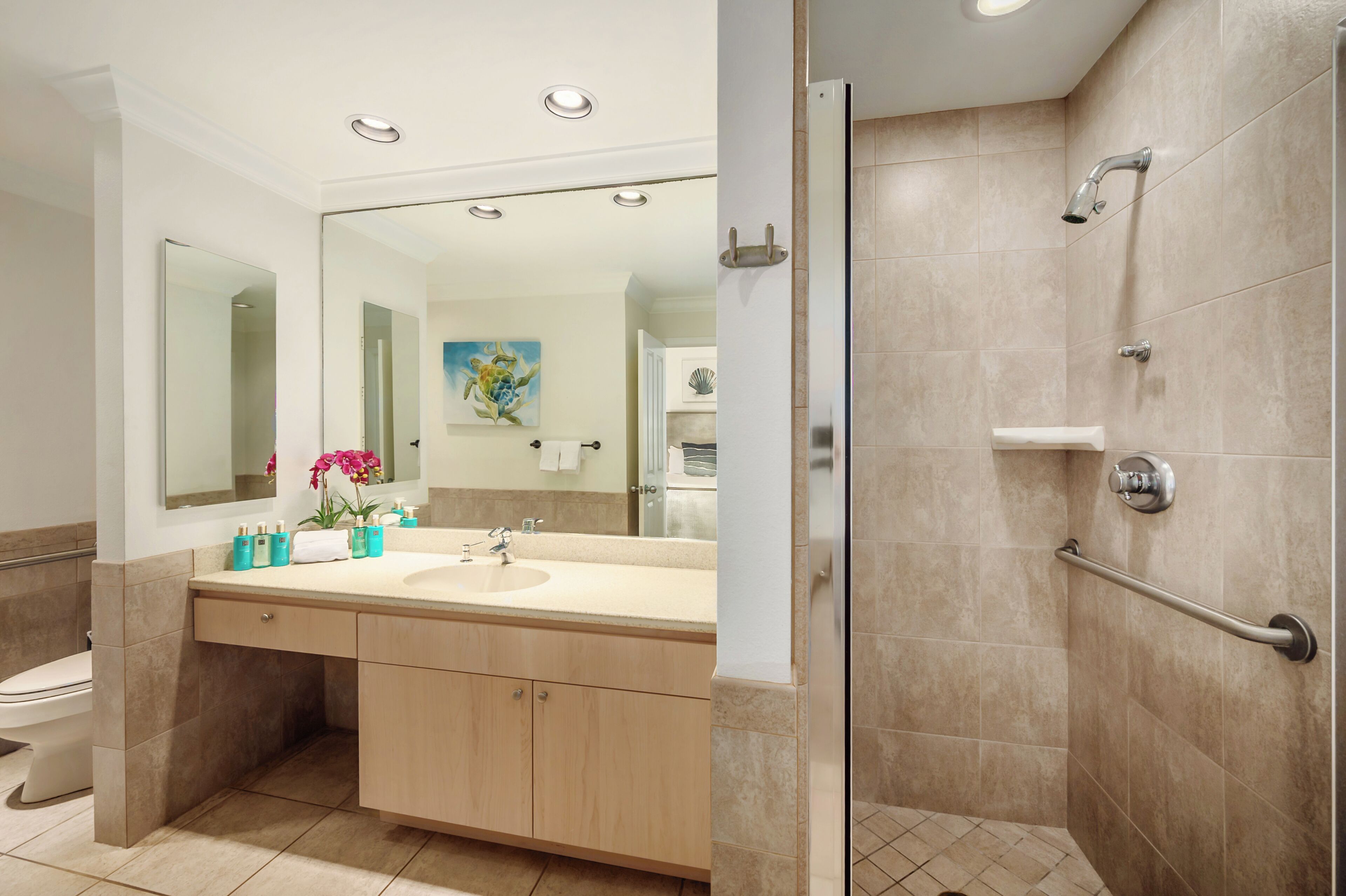 A bathroom with a sink, mirror, and shower.