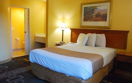 Premium bedding, desk, laptop workspace, blackout drapes. Americas Best Value Inn Addison Dallas