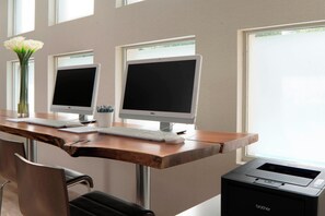 A workspace with two desktop computers, a keyboard, a mouse, a vase with flowers, and a Brother printer. - Four Points by Sheraton Dallas Arlington Entertainment District (Arlington)