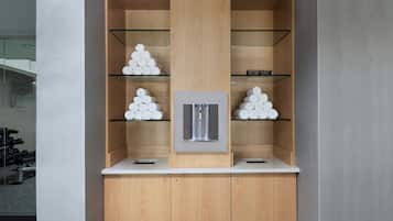 Une salle de bain moderne avec des meubles en bois, des étagères en verre et un lavabo central.