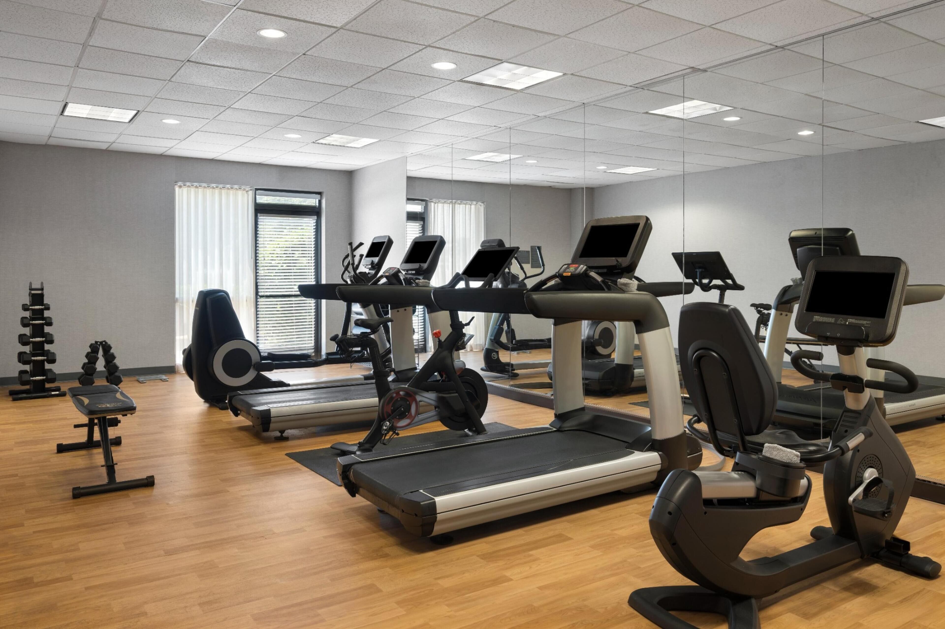 A gym with treadmills, elliptical machines, and weight equipment.