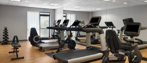 A gym with treadmills, elliptical machines, and weight equipment.