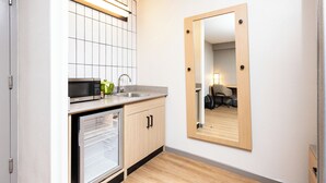 A compact kitchen with a microwave, sink, and refrigerator.