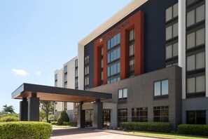 A modern hotel building with a prominent entrance, large windows, and a covered walkway. - Hyatt Place Dallas/Park Central (Dallas)