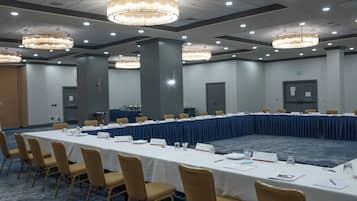 Una sala de conferencias con una larga mesa, sillas, tarjetas de identificación y plumillas.