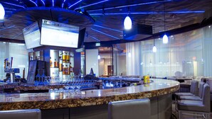 Un espace bar doté d’un comptoir en granit, de tabourets de bar et d’un écran de télévision.