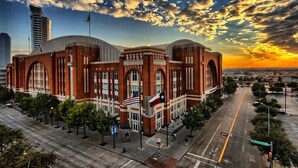 A large brick building with arched windows and multiple flags, including the American flag, located at a street intersection. - Crowne Plaza Dallas Downtown by IHG (Dallas)