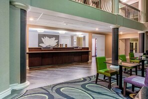 Experience the elegant lobby with a spacious layout, featuring a reception desk, comfortable seating, and a balcony offering a view of the area.
