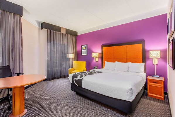 Relax in this stylish room with a large bed, side table, and corner table.
