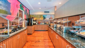 A buffet area with wooden flooring and glass display cases containing various food items. - Fairfield Inn By Marriott Raleigh Crabtree (Raleigh)