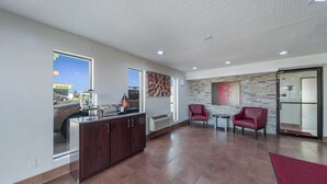Um quarto espaçoso com cozinha, área de estar com duas cadeiras e vista para o exterior.