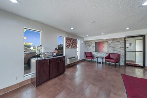 Una habitación amplia con cocina, una zona de estar con dos sillas y vistas al exterior.