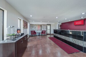 Un moderno vestíbulo de hotel con mostrador de recepción, zona de estar y señalización que indica acceso gratuito a Wi-Fi.