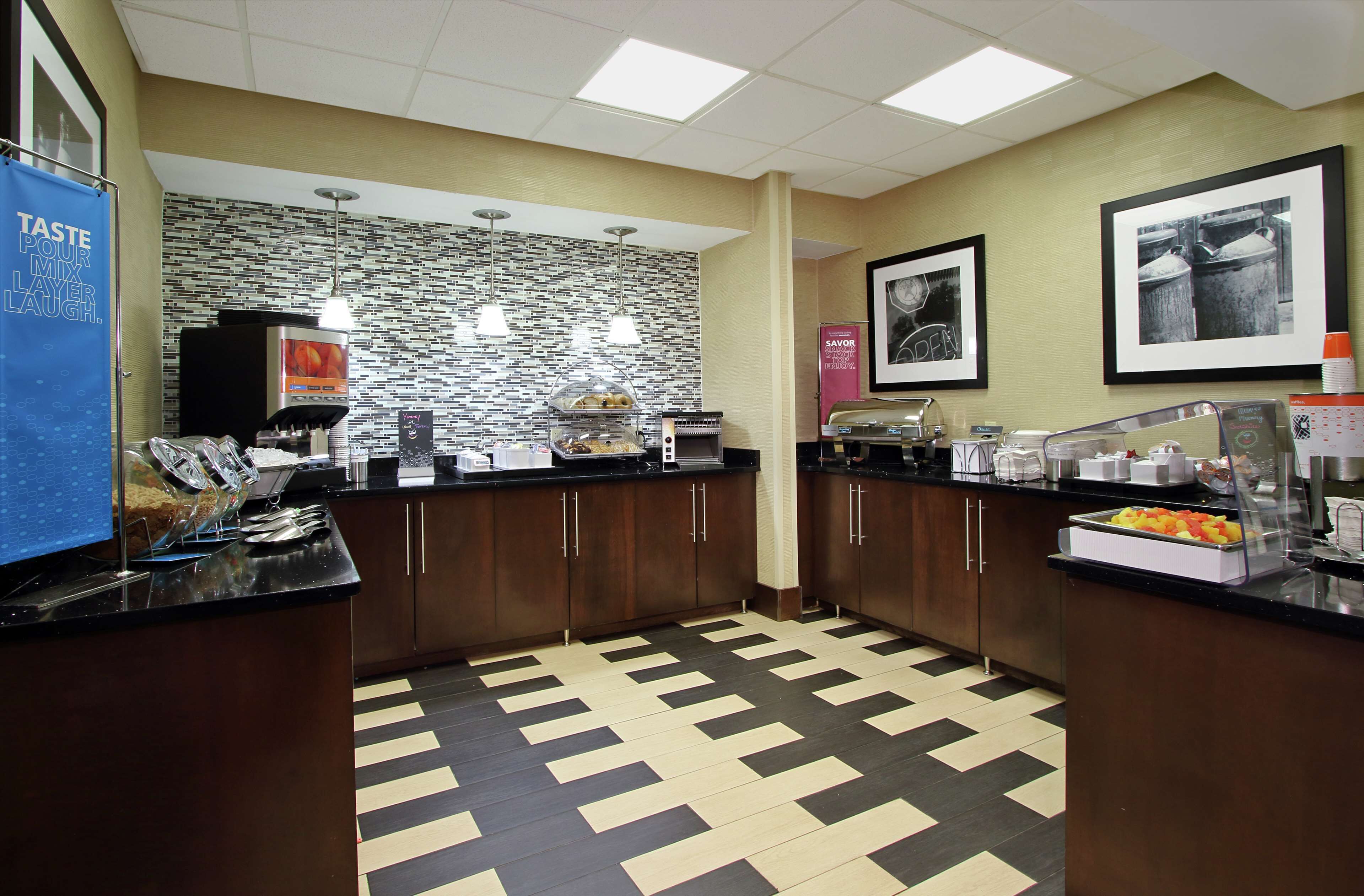 A hotel kitchen with a buffet setup, including a self-service station with various food items and a coffee station.