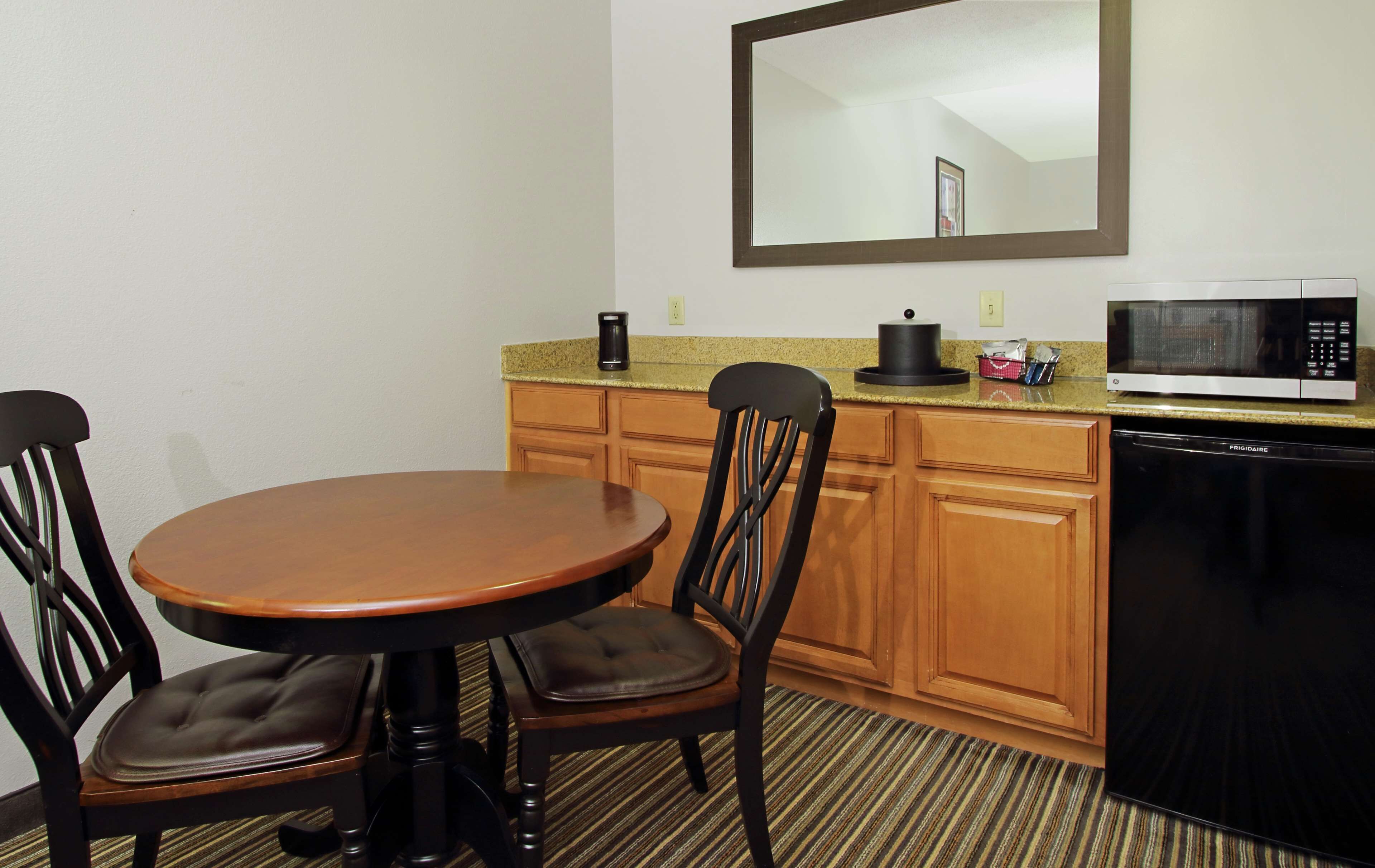 A compact kitchen with a dining table, chairs, a microwave, and a dishwasher.