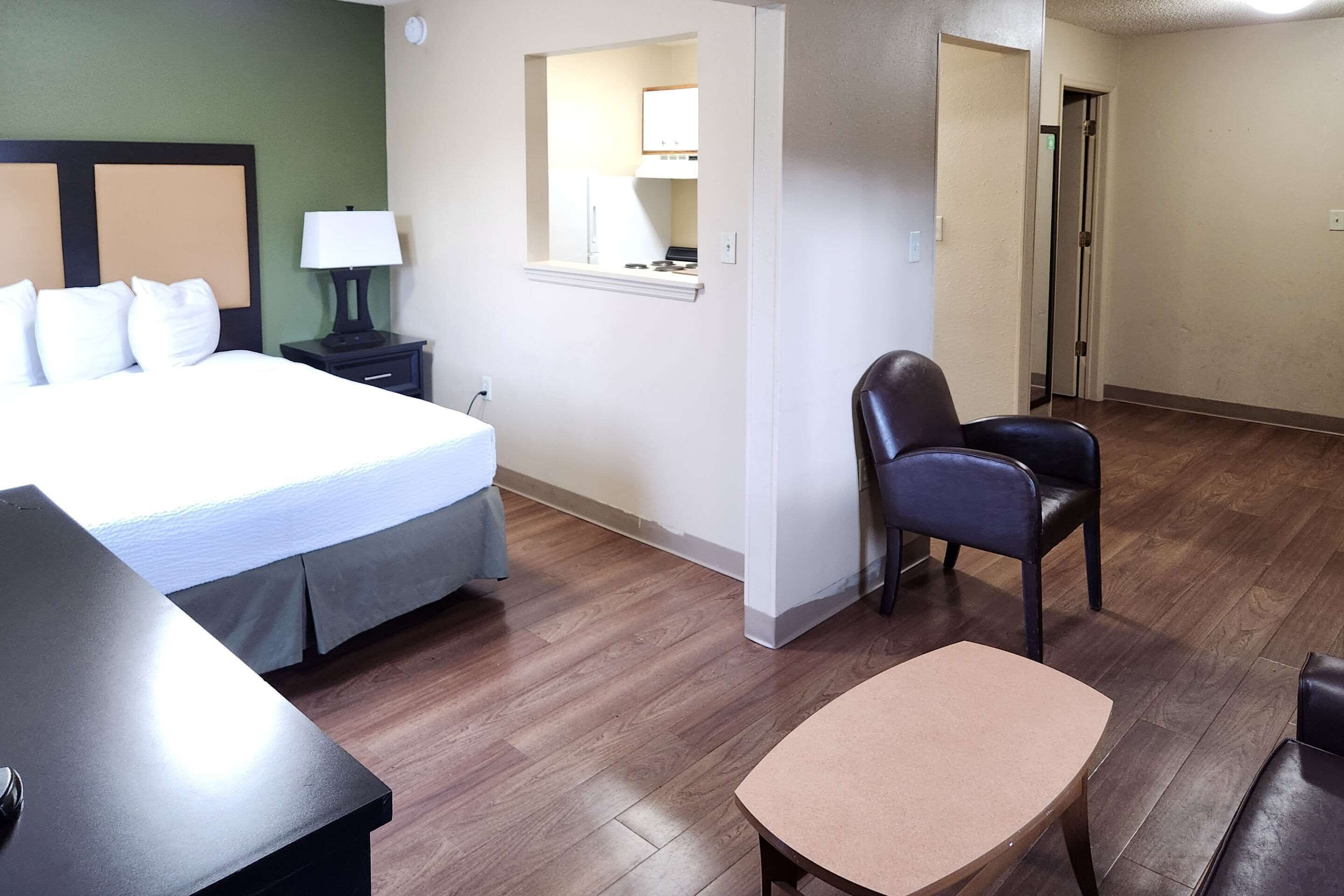 Una habitación de hotel con una cama, un escritorio, una silla y una mesita.